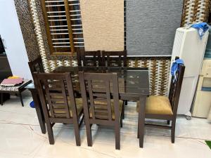 een houten eettafel met 4 stoelen bij J and A Hospitality in Bangalore