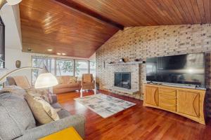 ein Wohnzimmer mit einem großen TV und einem Kamin in der Unterkunft On Misty Tides in Port Gamble