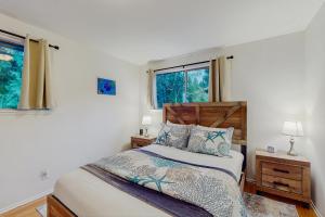 ein Schlafzimmer mit einem Bett und zwei Fenstern in der Unterkunft On Misty Tides in Port Gamble