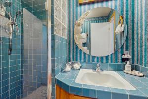 ein blau gefliestes Bad mit einem Waschbecken und einem Spiegel in der Unterkunft On Misty Tides in Port Gamble + 21 Fotos