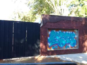 a wall with a painting on it next to a fence at Monoambiente céntrico in Puerto Iguazú