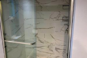 a shower with a glass door with marble at Tiny Lake Retreat in Sagle +16 photos