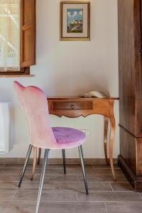 uma cadeira rosa sentada em frente a uma secretária em Tenuta Villa Febea em Chiusi
