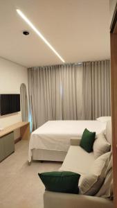 een hotelkamer met een bed en een bank bij Flat Beach Class Verano- Praia de Muro Alto- Porto de Galinhas in Ipojuca