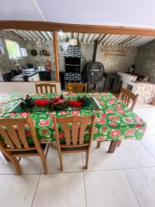 a table with a green table cloth with flowers on it at Recanto da Magia in Palhoça +51 photos