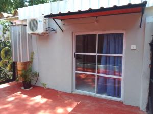 a door to a house with a window and a fan at Monoambiente céntrico in Puerto Iguazú