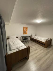 two beds in a room with a table in it at Hostel Casa Andalucia in Hallbergmoos