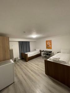 a room with two beds and a table in it at Hostel Casa Andalucia in Hallbergmoos