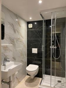 a bathroom with a toilet and a shower and a sink at Hostel Casa Andalucia in Hallbergmoos