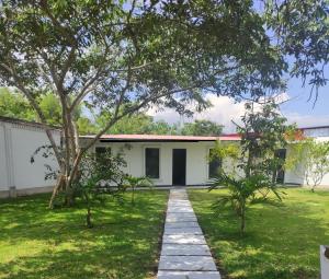 莫约班巴Wee House的院子里有一棵树的白色房子