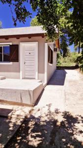 a white garage with a door on a house at Rohvolk chill aparts in Villa General Belgrano