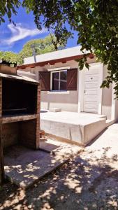 a white garage with a door and a window at Rohvolk chill aparts in Villa General Belgrano