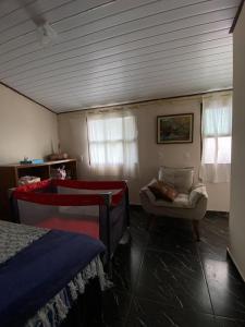a bedroom with a bed and a couch and a chair at Recanto da Magia in Palhoça