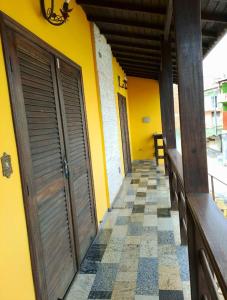 un edificio giallo con due porte e un pavimento piastrellato di Raízes de Afrodite quarto a São Thomé das Letras