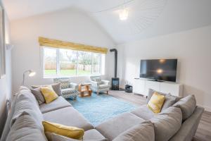 een woonkamer met een bank en een tv bij 100 Leiston Road, Aldeburgh in Aldeburgh