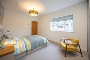 een slaapkamer met een bed, een stoel en een raam bij 100 Leiston Road, Aldeburgh in Aldeburgh +26 foto's
