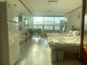 un dormitorio con una cama y un escritorio en una habitación en 범계역2분 거리 퀸침대2개 무료주차가능 뚫린뷰가 일품, 