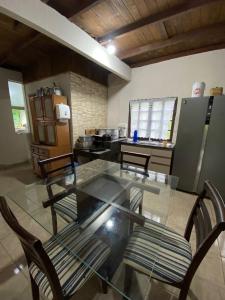 a dining room with a glass table and chairs at Recanto da Magia in Palhoça