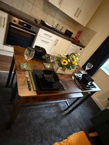 a table with glasses and flowers on it in a kitchen at Harbour Lights Retreat-Small and Cosy 1 bedroom in Ferryden +10 photos