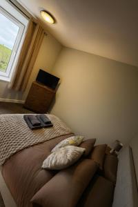 a bedroom with a bed with two pillows and a window at Harbour Lights Retreat-Small and Cosy 1 bedroom in Ferryden