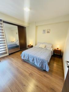 Familiar y equipado a pasos del Cine Center في كوتشابامبا: غرفة نوم بها سرير ومرآة كبيرة