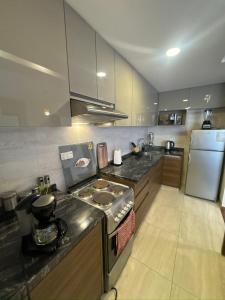 Familiar y equipado a pasos del Cine Center في كوتشابامبا: مطبخ مع موقد وثلاجة