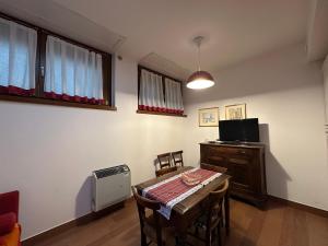 a room with a table and a tv and a table and chairs at 1000sogni in Limone Piemonte