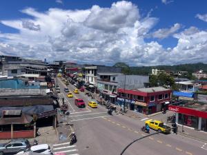a city street with cars and taxis on the road at Bambú Hostal in Tena