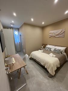 a bedroom with a large bed and a table at G&Ghomeciampinosuite in Ciampino
