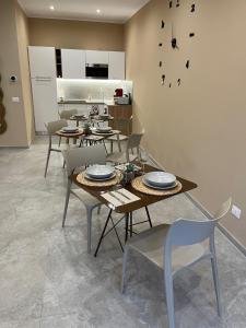 a dining room with tables and chairs and a clock on the wall at G&Ghomeciampinosuite in Ciampino