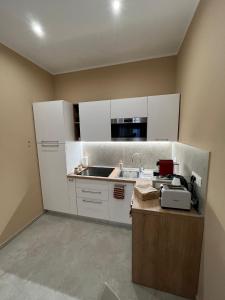 a kitchen with white cabinets and a sink at G&Ghomeciampinosuite in Ciampino +12 photos