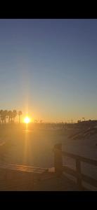 a sunset on the beach with a bench in the foreground at Oceano Unit B in Oceano +16 photos