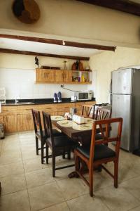 una cucina con tavolo, sedie e frigorifero di Stone Camp Naivasha a Naivasha