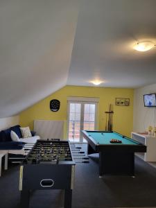 Zimmer mit zwei Billardtischen und einem Sofa in der Unterkunft Kuća za 10 osoba s jacuzzijem i biljarom Mrkopalj in Mrkopalj