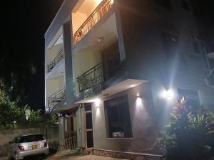 a building with a car parked in front of it at Panda hotel in Entebbe