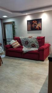 a red couch sitting in a living room at Casa aconchegante e familiar no bairro Vila Nova in Joinville