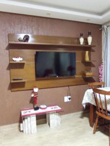 a living room with a flat screen tv on a wall at Casa aconchegante e familiar no bairro Vila Nova in Joinville