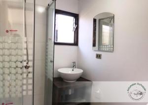 a bathroom with a sink and a glass shower at Cabañas Antumalen Vichuquén in Lago Vichuquen