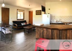 a kitchen and a living room with a table and a refrigerator at Cabañas Antumalen Vichuquén in Lago Vichuquen