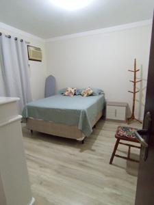 a bedroom with a bed and a chair at Casa aconchegante e familiar no bairro Vila Nova in Joinville
