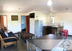 a kitchen and living room with a table and a refrigerator at Cabañas Antumalen Vichuquén in Lago Vichuquen