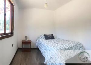 a bedroom with a bed with a pillow on it at Cabañas Antumalen Vichuquén in Lago Vichuquen