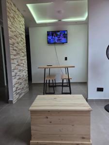 stół z krzesłem i telewizor na ścianie w obiekcie Hermoso y acogedor apartamento en conjunto cerrado w mieście Ibagué
