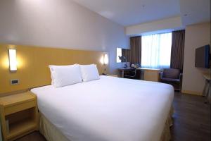 a large white bed in a hotel room at Holiday Inn Express Taoyuan by IHG in Taoyuan