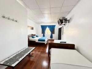 a room with two beds and a couch in it at Hostal Maravilla Amazónica in Iquitos