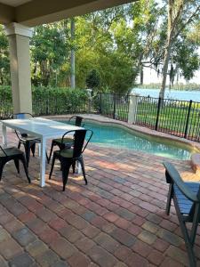 un tavolo bianco e sedie accanto a una piscina di Lakeside Retreat with pool, dock & game room a Interlachen