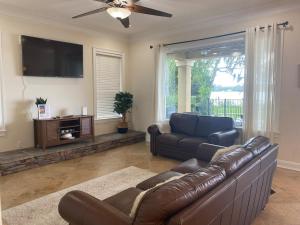 un soggiorno con un divano in pelle e una televisione di Lakeside Retreat with pool, dock & game room a Interlachen