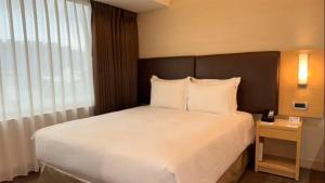 a bedroom with a large bed with white pillows at Holiday Inn Express Taoyuan by IHG in Taoyuan