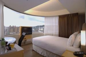 a bedroom with a white bed and a large window at Holiday Inn Express Taoyuan by IHG in Taoyuan