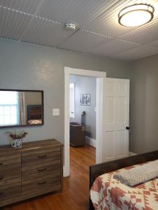 a bedroom with a bed and a dresser and a mirror at Apt 2 2nd Floor in the Heart of the City in Worcester +17 photos